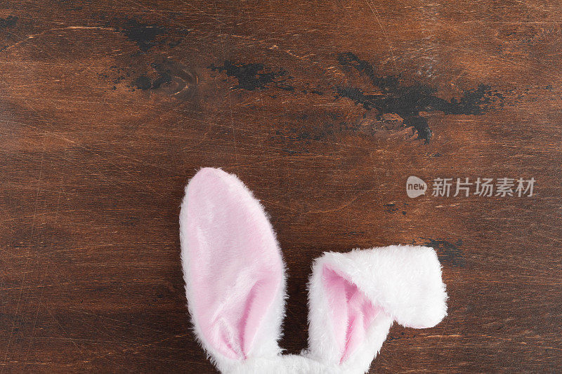 装饰和符号俯视图。复活节快乐节日背景概念。平放配件兔子耳朵在木桌上。为设计或文本提供自由空间。