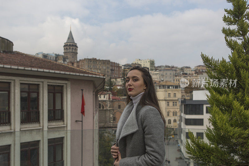 一名年轻的俄罗斯女子在土耳其伊斯坦布尔卡拉科伊的屋顶咖啡馆拍照