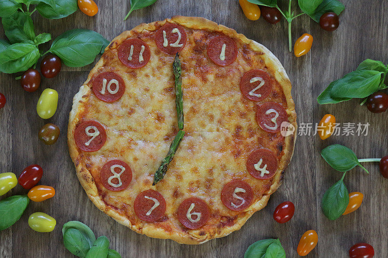 这是一个自制披萨时钟的图片，上面有意大利辣香肠片、马苏里拉奶酪和芦笋作为时钟指针，显示时间07:00七点。这是意大利披萨餐厅为孩子们的生日派对提供的儿童披萨时钟