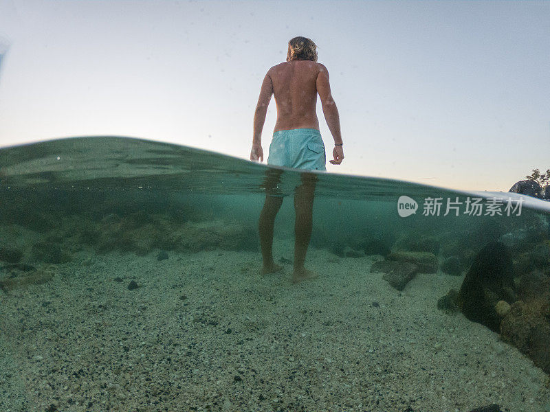 一个人站在海滩上做白日梦的水下镜头