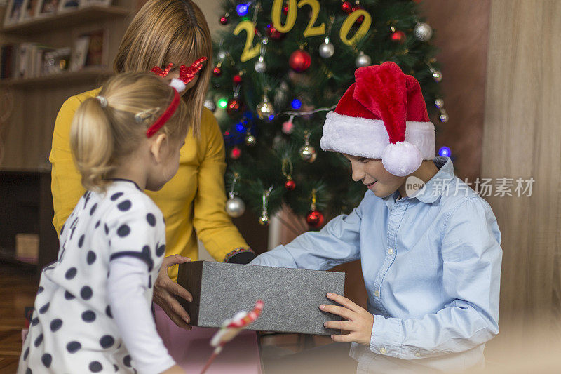 女孩在看她哥哥的圣诞礼物