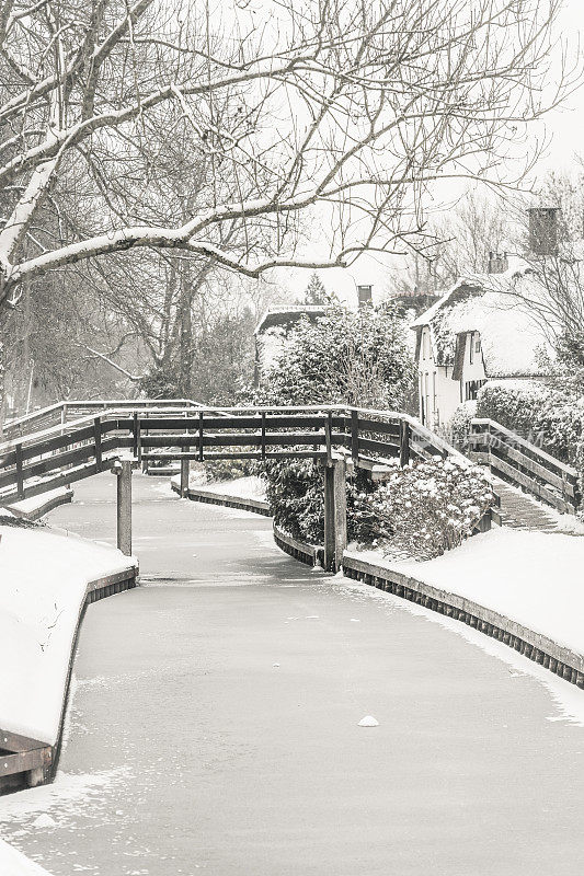 在一个寒冷但美丽而平静的冬天，Giethoorn村的运河和积雪