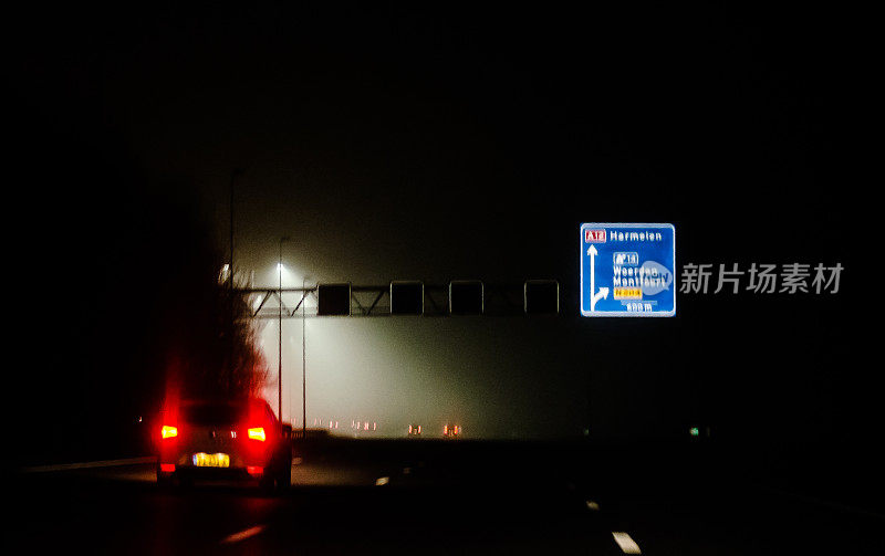 高速公路上的汽车在一个雾蒙蒙的夜晚在荷兰的高速公路上行驶