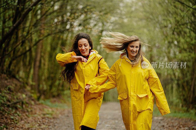 两个穿着黄色雨衣的年轻女子在雨中