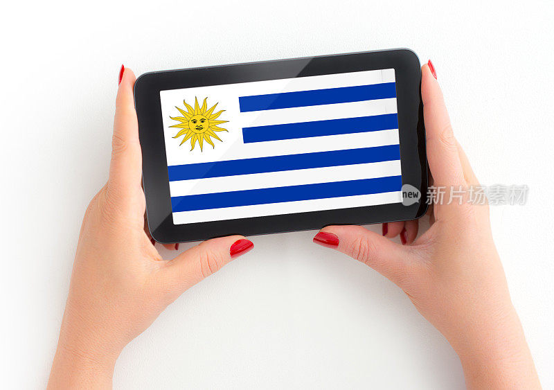 乌拉圭国旗在数字平板电脑在成熟女性的手与个人观点