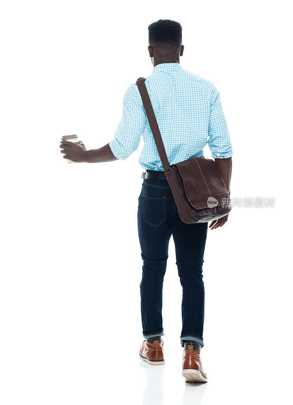 非裔美国青年男性走在白人背景下，背着肩包，拿着包
