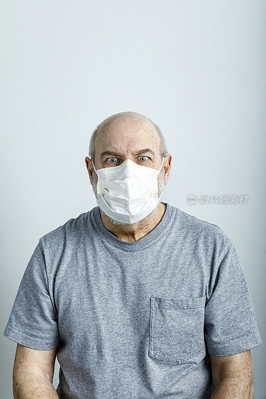 害怕的老人戴着医用外科口罩