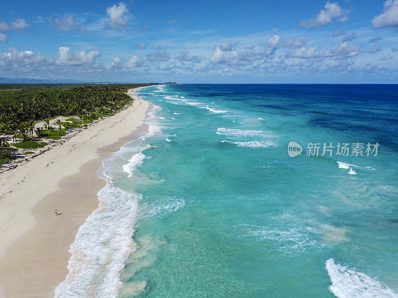 女人沿着海滩行走的鸟瞰图