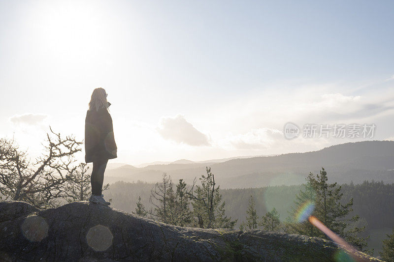 一名女性徒步旅行者在山脊上停下来