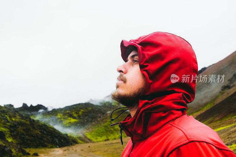 一名游客徒步穿越冰岛风景优美的地热山谷