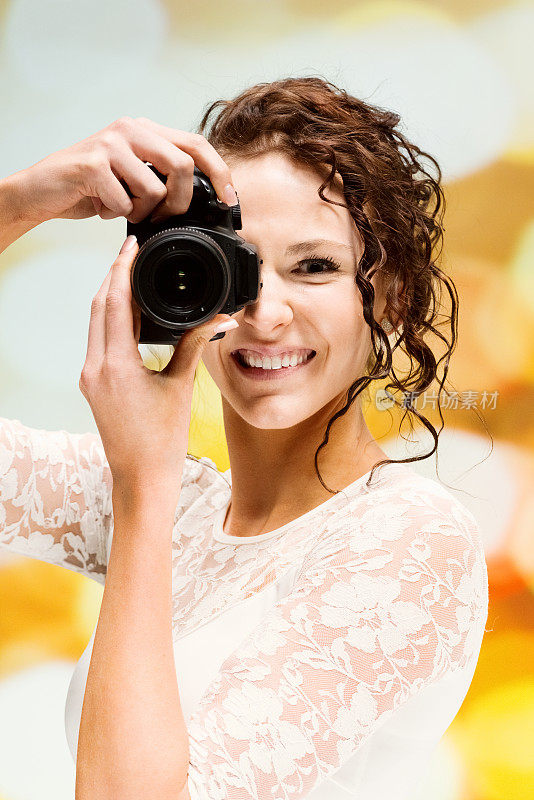 白种人年轻女性摄影师在散焦背景穿着裙子和拿着相机