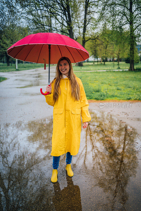 快乐的女人在雨中行走