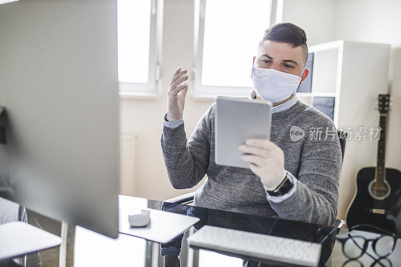 商人使用数码平板电脑，戴着防护口罩和外科手套