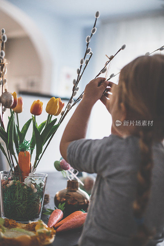 小女孩帮着装饰复活节的郁金香花束