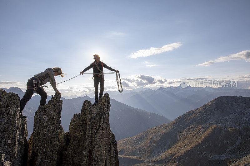 登山运动员爬上岩石的顶峰
