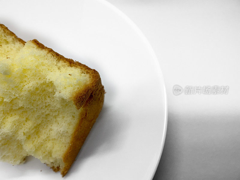 把剩下的黄色蛋糕放在白色的盘子里吃