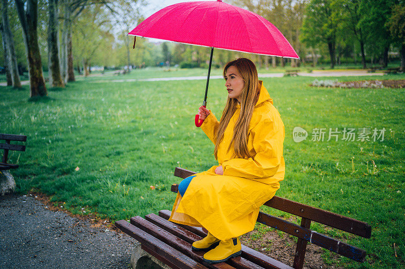在雨中打着红伞的女人