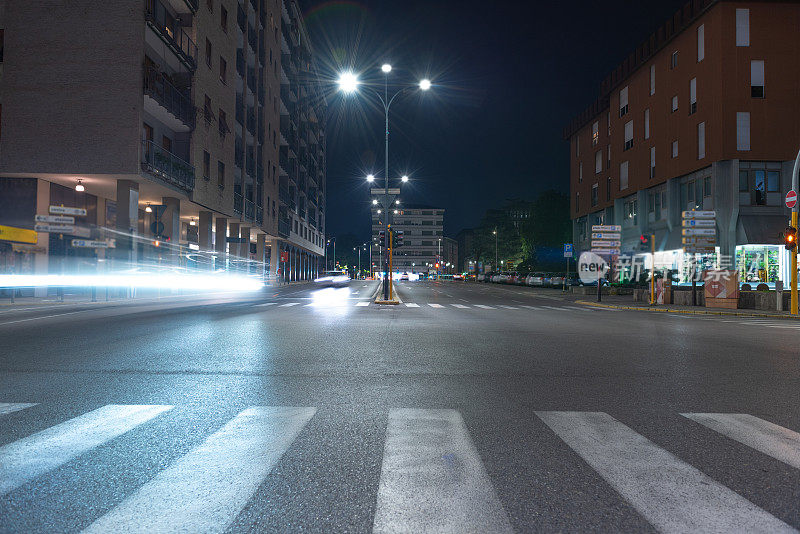 城市夜晚十字路口交通的时间推移视图。晚间意大利城市运动。