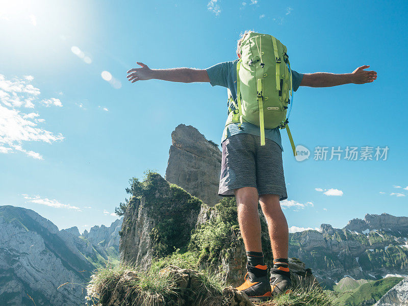 男人在山顶张开双臂