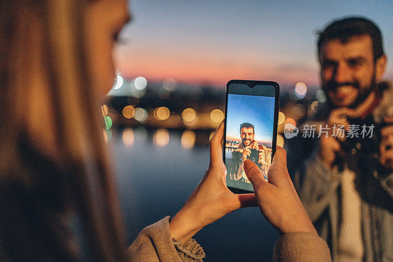 女朋友在晚上用手机给男友拍照