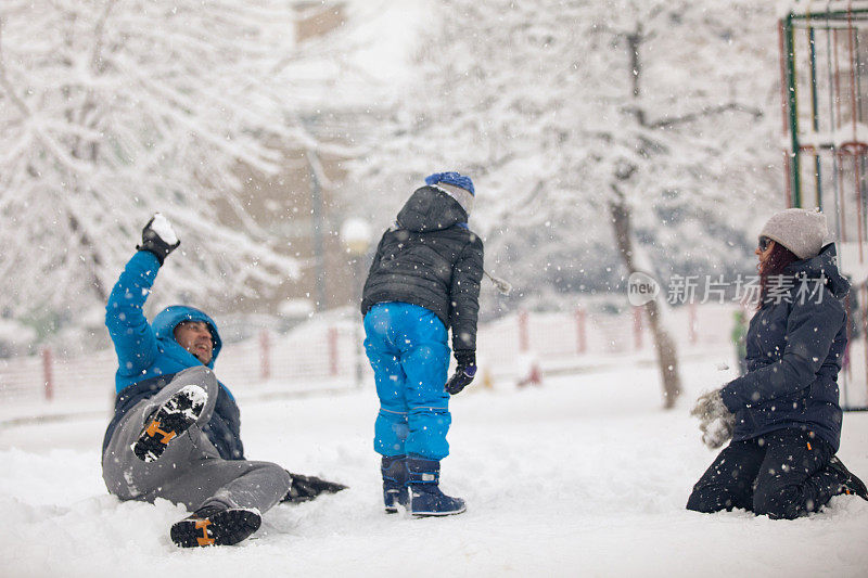 快乐的家庭在雪地上玩耍