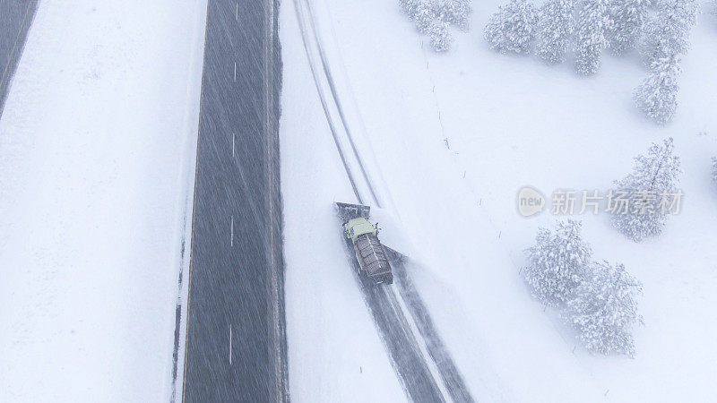 航拍图:在暴风雪中，铲雪车在高速公路上清理并撒盐。