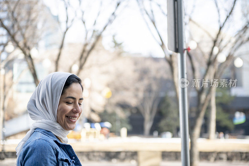 年轻漂亮的穆斯林移民在城市里微笑