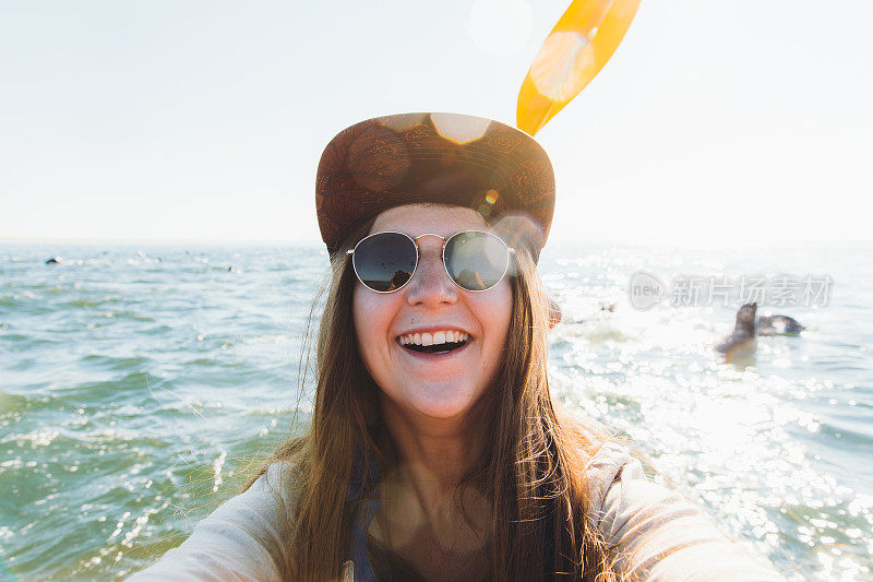 年轻快乐的女人在阳光明媚的一天在纳米比亚的海洋皮划艇自拍照片