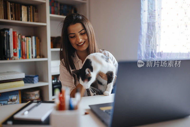 一位年轻女子在家上网络课时被她的猫打扰