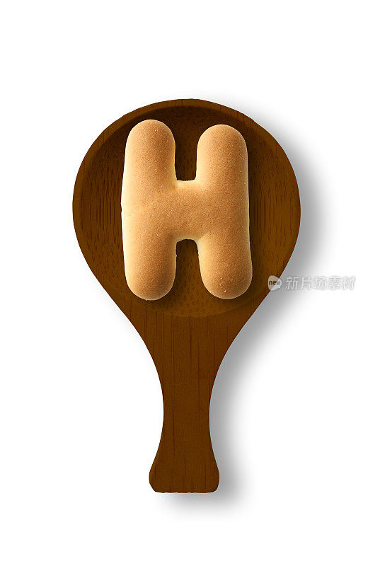 孤立的照片的大写字母饼干H上的木勺，在白色的背景
