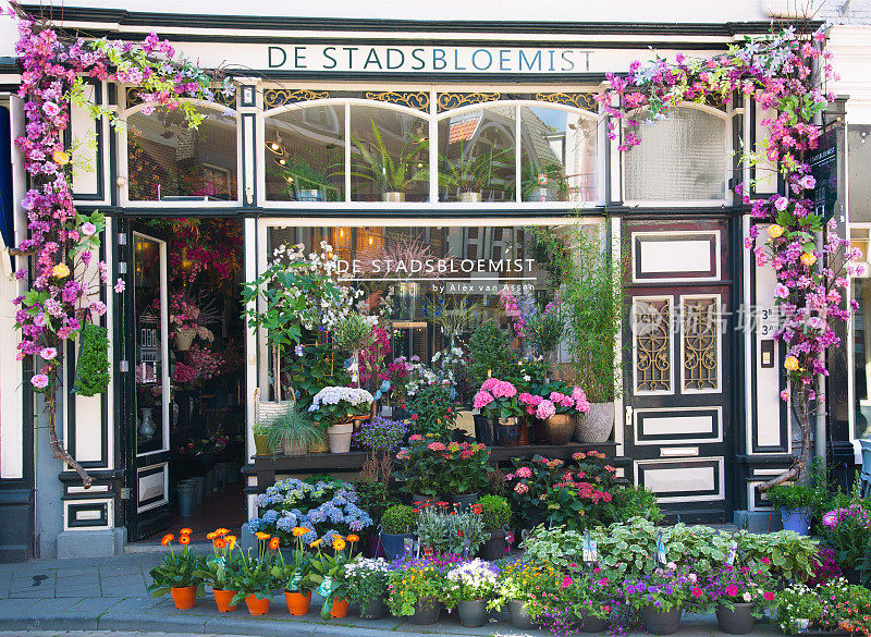 城市花店与郁郁葱葱的花装饰。