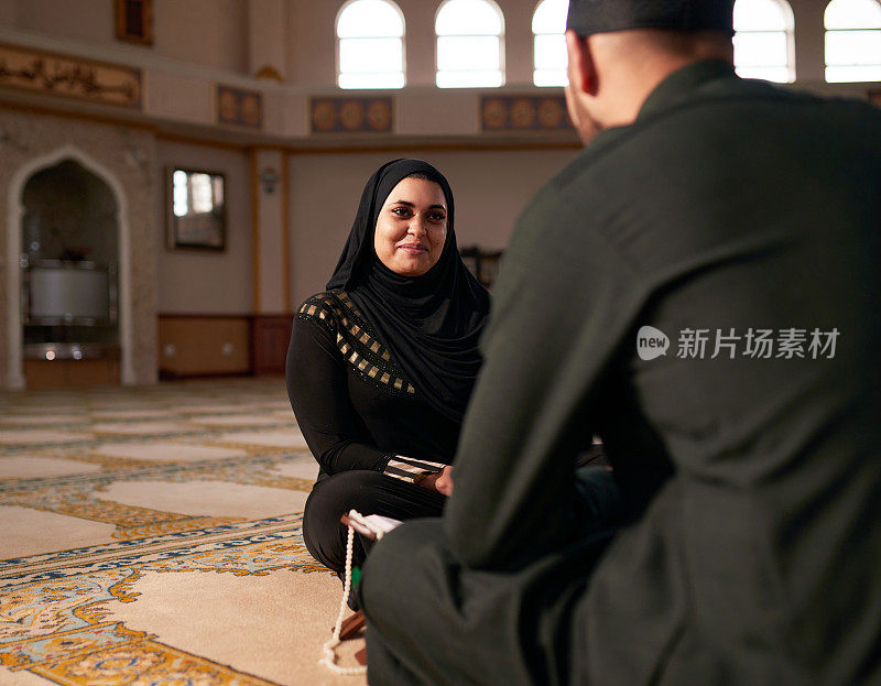 一名年轻的穆斯林妇女和她的丈夫在清真寺祈祷