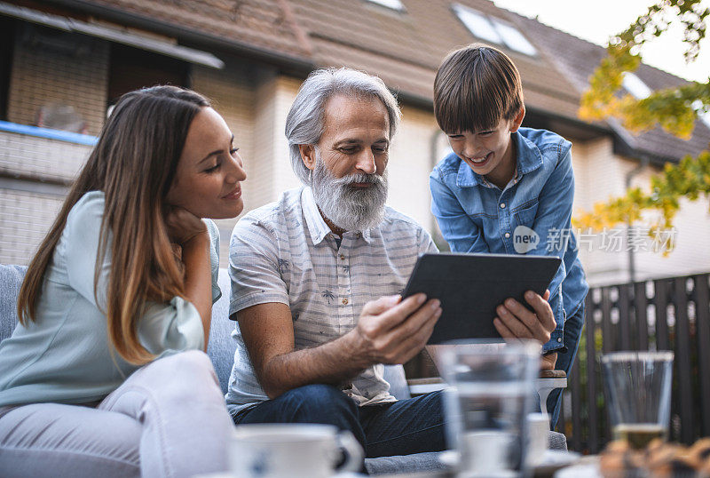 老人，他的女儿和孙子使用数字平板电脑