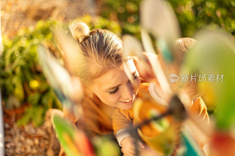 晚夏初秋时节，在院子里，妈妈和男孩和奶奶一起在院子里玩耍