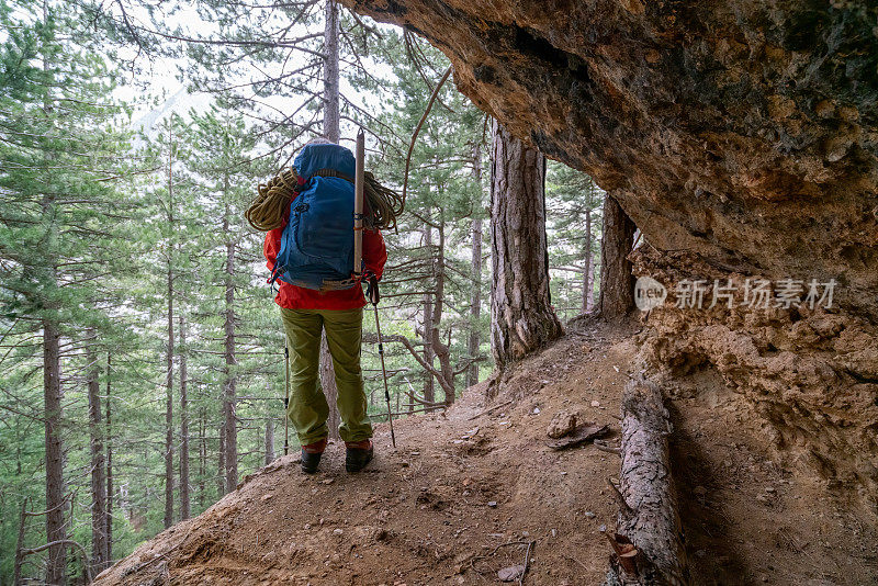 图为，一名女登山者在落基山的一个山洞里观看森林、峡谷的美景