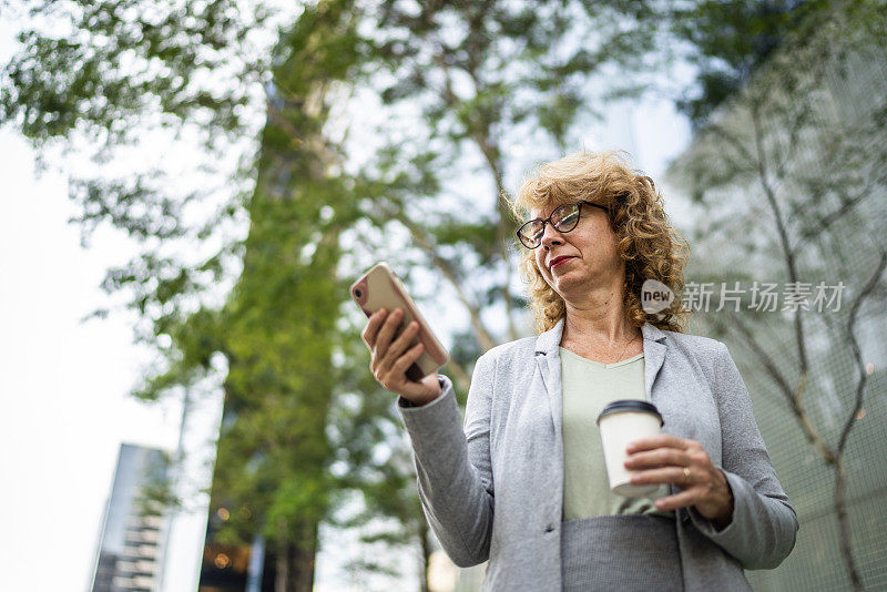 商务女性在户外使用智能手机