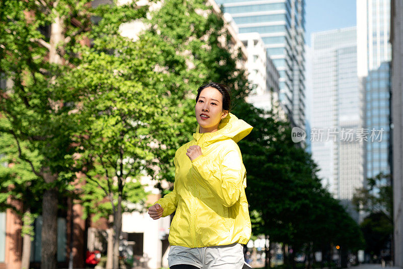 年轻女子在城市街道上奔跑