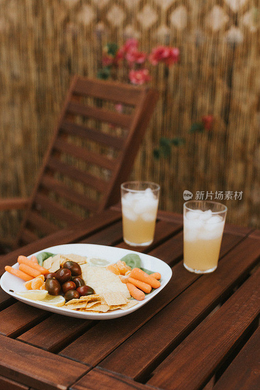 深色木制户外露台桌上放着零食