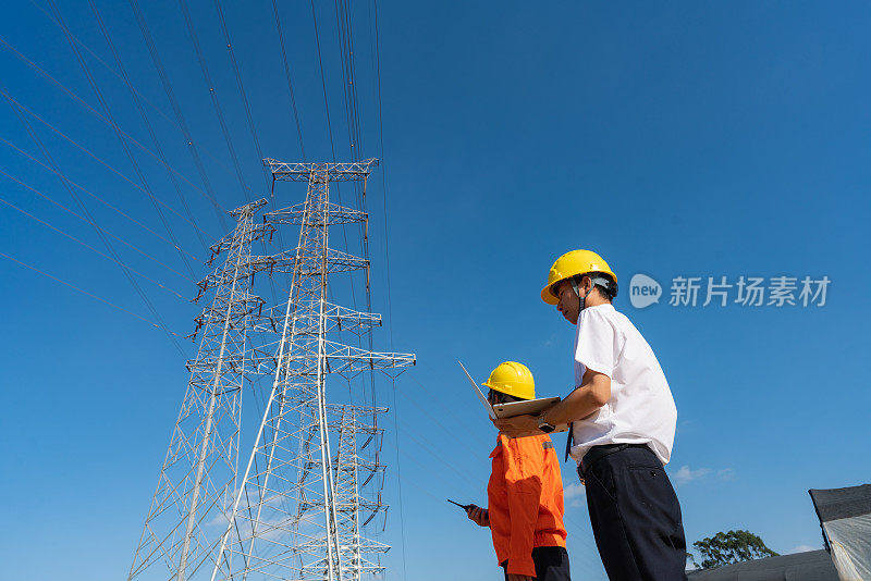 电力工程师和工人在现场检查输电线