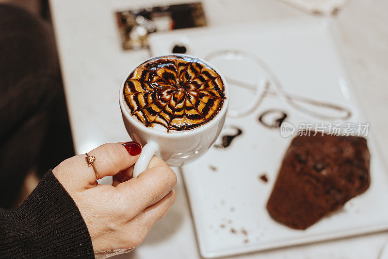 女人在咖啡馆吃咖啡和巧克力饼干，可可饼干和咖啡，甜的食物与咖啡，咖啡艺术