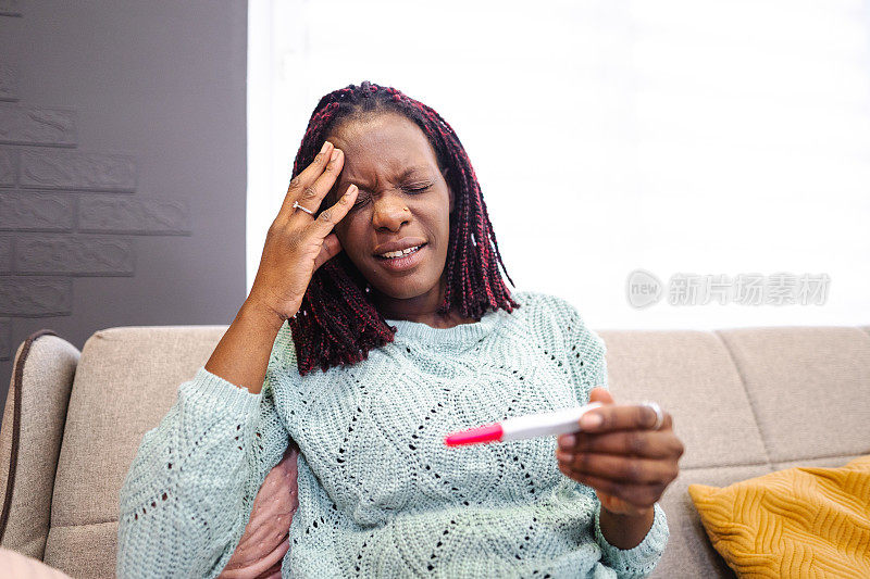 焦虑的黑人妇女拿着验孕棒