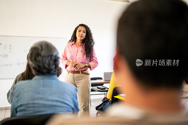 中年成人教师在大学课堂上回答大学生的问题