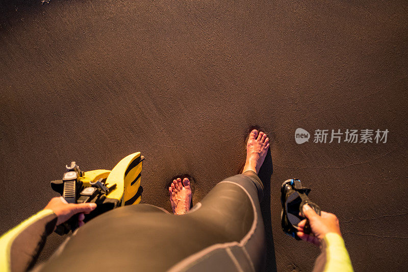 带着脚蹼和潜水面罩的女人走在沙滩上。观点。