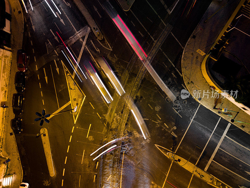航拍无人机在里斯本的一个广场上拍摄的交通，晚上有彩色的灯光轨迹