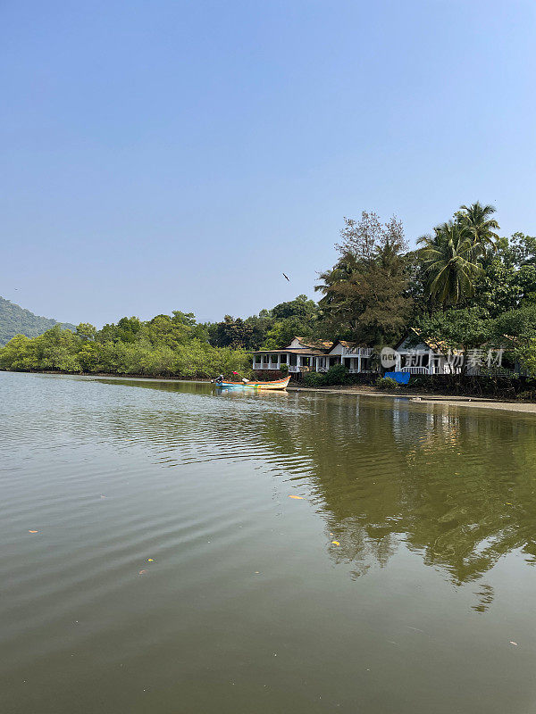 在泻湖水边的沙滩上的海滩房屋的图像，重点在前景