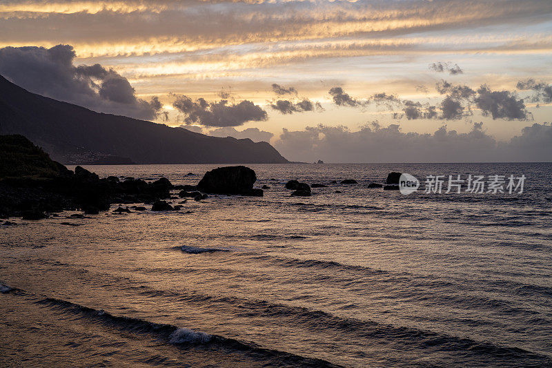 蓝色的海浪冲刷着落日的海滩