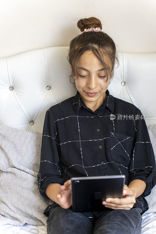 女孩在使用数码平板电脑。
