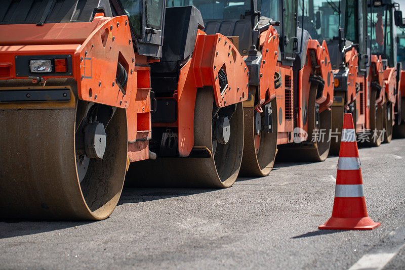 路边有压路机，道路分界线上有交通锥