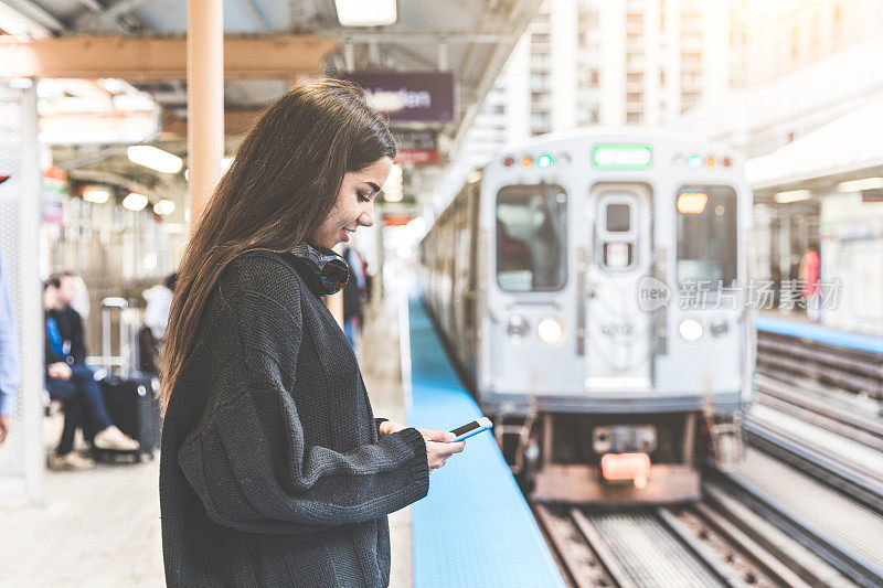 在芝加哥火车站用智能手机的女孩