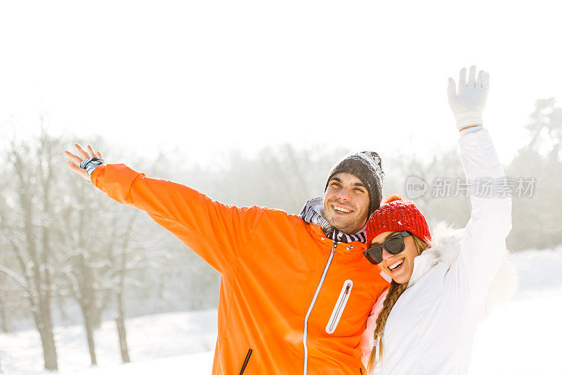 一对夫妇举着手臂站在雪地里